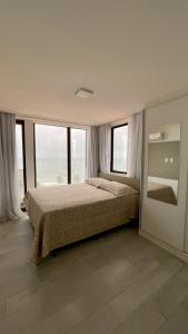 康德Apartamento Praia de Carapibus的一间卧室设有一张床和一些窗户。