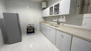 艾卜哈جنان المحاله的白色的厨房配有水槽和冰箱