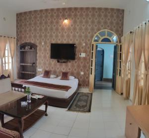 瓦拉纳西湿婆恒河景观旅馆的一间酒店客房,配有一张床和一台电视