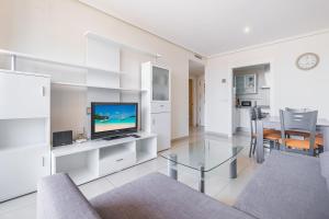 贝尼多姆Gemelos 26 Resort Apartment 9-C Levante Beach的一间带电视和桌子的客厅