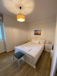 阿纳维索斯Sea Through Apartment Anavissos的卧室配有白色大床和灯