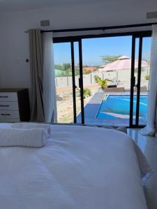 恩多拉Swiss Luxury Apartments的一间卧室配有一张床,享有游泳池的景色