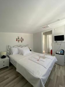 伊斯坦布尔Heybeliada Pansiyon的卧室配有一张白色大床和一台平面电视。