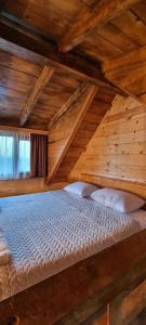K'veda BzubzuShato Maxuntseti的木制天花板的客房设有一张大型木床。