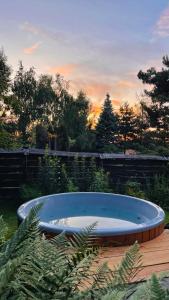 日基Domek Mały Las的庭院内的热水浴池,享有日落美景