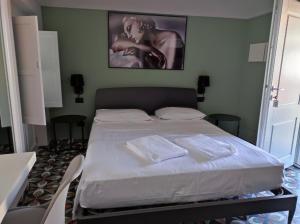 萨卢佐Hotel & Apartments " Perpoin "的一间卧室配有一张床,上面有两条毛巾