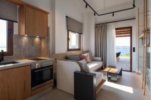 阿莫利亚尼岛Sun rise Villas ammouliani的厨房以及带沙发和桌子的客厅。