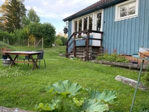 MunkforsRustic Haven Bed and Breakfast near Klarälvsbanan and Swimming area的一个带野餐桌和房子的花园