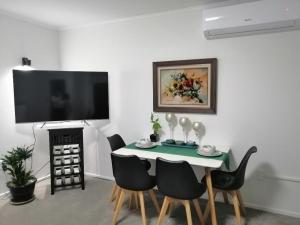 奥克兰Centre Takapuna 2 Beds & Garage & Netflix的一间带桌椅和电视的用餐室