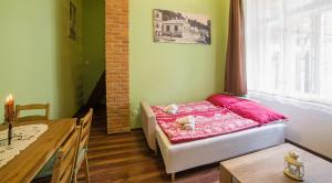 班斯卡 - 什佳夫尼察Apartmán u Bretschneidera的一间卧室配有一张带粉色床单和一张桌子的床。