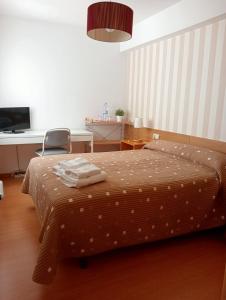 圣地亚哥－德孔波斯特拉PR拉巴斯酒店的一间卧室配有一张带桌子和椅子的床