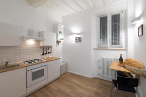 佩鲁贾PINTURICCHIO Guest House的厨房配有白色家电和木桌