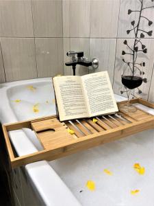霍茨科波霍尔耶Luxury Wide View Apartment Pohorje Bellevue的装在浴缸里的装有葡萄酒杯的托盘上的书
