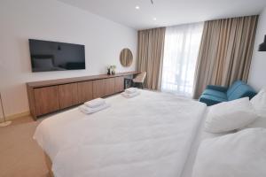 布德瓦Luxury Hotel Riva - Budva的酒店客房设有一张白色大床和一台电视。