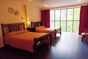 科恰班巴Hotel Maison Fiori Prado的酒店客房设有两张床和大窗户。
