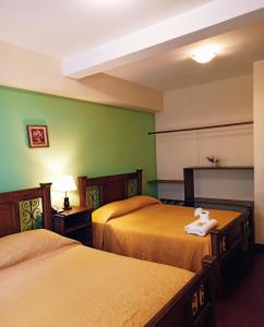 科恰班巴Hotel Maison Fiori Prado的绿墙旅馆客房的两张床