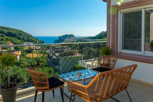 帕尔加Natura Luxury Suites Parga的阳台配有桌椅,享有风景。