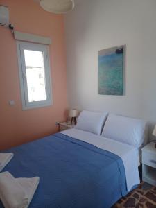 利普西岛Orizodas的一间卧室设有蓝色的床和窗户。