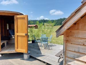 La Chaux-du-MilieuDrosera cabane et roulotte的木制甲板上配有桌椅