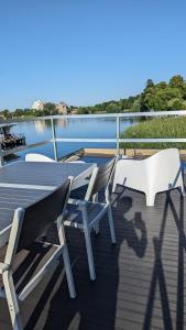 菲尔斯滕贝格Waterview - Schwimmendes Ferienhaus auf dem Wasser mit Blick zur Havel, inkl Motorboot zur Nutzung的船上甲板上的两把椅子和一张桌子