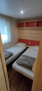 圣西普里安Mobil home 6-8 places en Camping 4etoiles Saint Cyprien的小型客房 - 带2张床和窗户