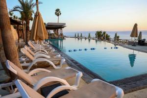 索瓦马O Beach Hotel & Resort的一个带躺椅和遮阳伞的游泳池