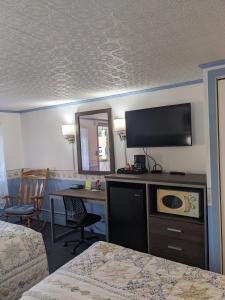 本宁顿本宁顿汽车旅馆的酒店客房配有一张床和一张书桌及一台电视
