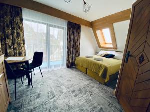 布科维纳-塔钱斯卡Willa Koszysta的一间卧室配有一张床、一张书桌和一个窗户。