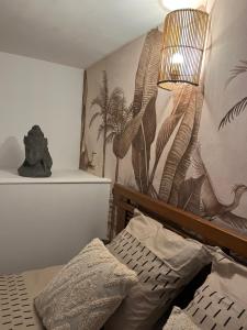 敦刻尔克Malo, Duplex bord de mer accès direct plage en rdc的一间卧室配有一张床和一堵带植物壁画的墙壁