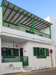 普拉亚布兰卡Casa mar y cielo的白色的建筑,设有绿色百叶窗和阳台
