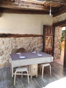锡古恩萨Casa rural El Rincón de las Estrellas的石墙客房内的桌椅