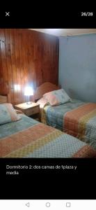 黑岛La estancia en la Isla的一间设有两张床和台灯的房间