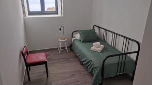 奥尔塔Costa do Moinho的卧室配有床、椅子和窗户。