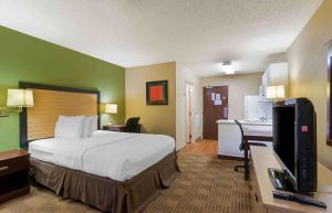 雷内克萨Extended Stay America Suites - Kansas City - Overland Park - Quivira Rd的酒店客房配有一张床和一张书桌及一台电视