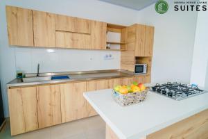 阿帕尔塔多Sierra Verde Living的厨房配有木制橱柜和一篮水果