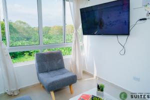 阿帕尔塔多Sierra Verde Living的客厅配有椅子和平面电视