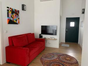 塞亚Casa do Bairro的客厅配有红色沙发和电视