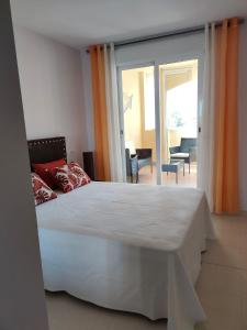 维拉EDA Paradise Vera Playa的一间带一张白色大床的卧室和一个阳台