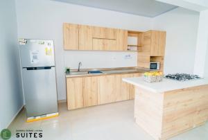 阿帕尔塔多Sierra Verde Living 2的厨房配有木制橱柜和不锈钢冰箱。