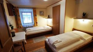 洛弗附近魏斯巴赫Gasthof Geronimo的小房间设有两张床和窗户