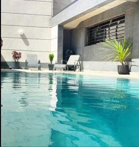 丹吉尔Villa piscine sans vis à vis vue mer的一座带两把椅子的游泳池位于大楼旁