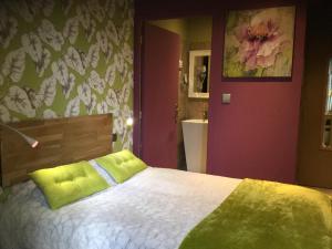 蒙托邦商务酒店的一间卧室配有一张带绿色枕头的床