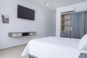 圣克鲁斯华特库Casa Xtao Hotel的一间卧室配有一张床,墙上配有电视