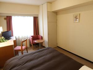 横滨HOTEL LiVEMAX BUDGET Yokohama Kannai的酒店客房,配有一张床、一张桌子和椅子