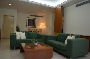 吉隆坡枫叶套房的客厅配有两张绿色沙发和一张桌子