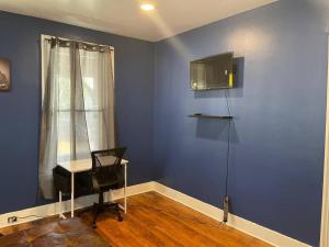 梅里登fashionably cozy place的一间设有蓝色墙壁、椅子和书桌的客房