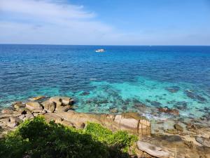 涛岛道通别墅2号旅馆的岩石海岸边的水中的小船