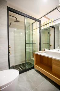 张家界武陵山水客栈Wuling Shanshui Hotel的浴室配有卫生间、盥洗盆和淋浴。
