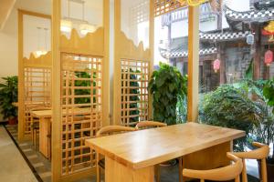 张家界武陵山水客栈Wuling Shanshui Hotel的用餐室配有木桌和椅子