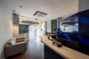 新加坡Fragrance Hotel - Classic的大堂配有沙发和大屏幕平面电视。